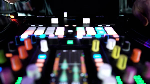 Deejay playing electronic music on turntable with colorful buttons, time lapse effect. Art. Dj touching vinyl, sliders at the night club. — Stock Photo, Image