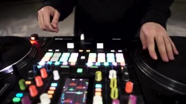 DJ 'in gece kulübünde elektro müzik çalması için modern bir ses mikseri kullanmasını kapat. - Sanat. Renkli Düğmeler ve Vinil, DJ ekipmanı.