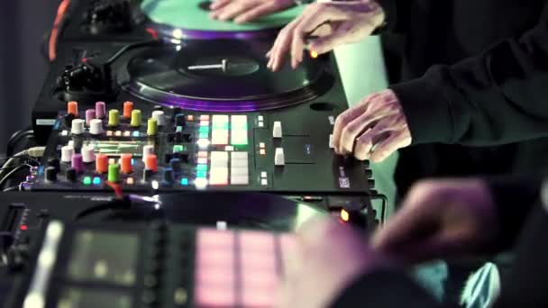 Skupina DJ používá konzoli pro míchání taneční hudby v diskotékovém klubu. Umění. DJ pás a mixážní paluba, zblízka boční pohled. — Stock video