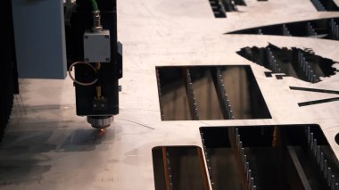 Teknoloji sergisinde endüstriyel ekipman sunumu. HDR. Lazer metal kesme makinesi metal metal bir levhada kalp şeklinde bir delik açıyor..