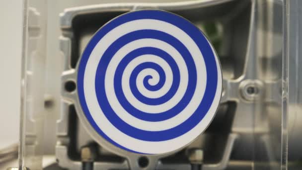 Close up of spinning mechanism creating hypnotic effect. HDR. White rotating circle with dark blue spiral, seamless loop. — Stock Video