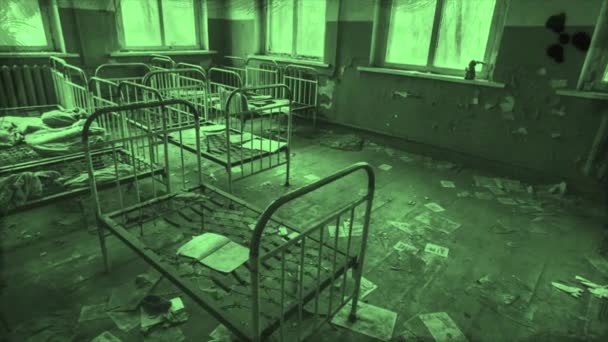 Dormitorio de niños abandonados en el jardín de infantes, detalles de una ciudad fantasma en colores geen, Pripyat, Ucrania. Moción. Espantosas camas de metal antiguas para niños dentro del edificio en ruinas. — Vídeos de Stock