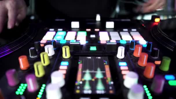 Deejay jouer de la musique électronique sur la platine avec des boutons colorés, effet time lapse. L'art. Dj touchant vinyle, curseurs à la boîte de nuit. — Video