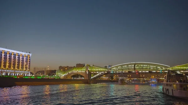 Prachtige gloeiende gebouwen aan de dijk. Actie. Boottocht langs het stadskanaal met uitzicht op gloeiende gebouwen. Gloeiende gebouwen en bruggen in de buurt van het stadskanaal in de avond — Stockfoto