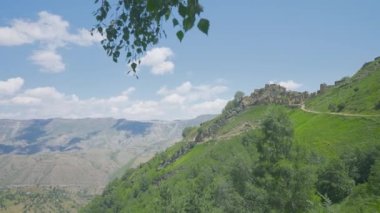 Dağ yamacındaki taş kalıntıları. Başla. Taş kalıntıları olan güzel yeşil dağ yamacı. Güneşli bir günde yeşil yamaçları ve antik kalıntıları olan pitoresk dağ manzarası