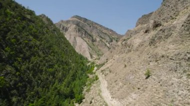Ormanlık dağ manzarası ve kayalık. Başla. Dağ yamaçlarında farklı manzaralar var. Çamurlu yamaç dağlardaki boş kayalık yamaca bağlanır