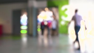 Alışveriş merkezindeki insanların geçmişi bulanık. HDR. Yürüyen erkek ve kadınların olduğu bir alışveriş merkezinde odaklı olmayan manzara.