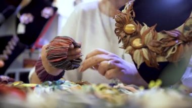 Yaprak yaprağı gibi görünen kalın kumaş parçalarından yapılmış el bandı olan kadın. - Sanat. El işi mücevherleri olan bir atölyenin içinde..