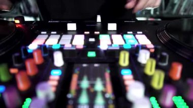 DJ renkli tuşlarla, zaman aşımı efektiyle turntable 'da elektronik müzik çalıyor. - Sanat. DJ plağa dokunuyor, gece kulübünde kayıyor..