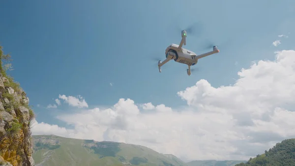 Quadcopter voando no fundo das montanhas e do céu. Acção. Quadricóptero profissional para fotografar enquanto viaja. Quadcopter sobe e tira fotos de paisagens de montanha — Fotografia de Stock