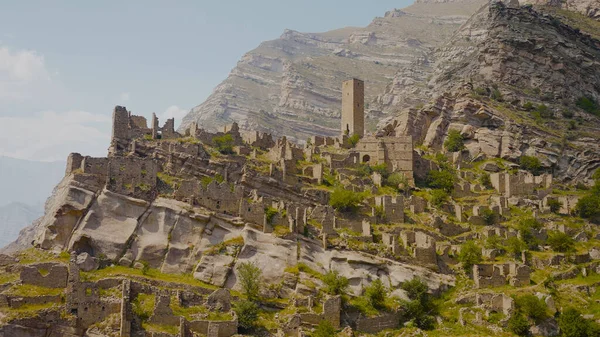 Ruinas de la antigua ciudad en las rocas en el día soleado. Acción. Ciudad de piedra sobre roca en las montañas. Ciudad histórica de piedra sobre roca sobre valle de montaña — Foto de Stock