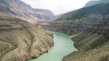 Geniş, sakin nehri akan dağlık bölgenin havadan görünüşü. Başla. Yüksek uçurumlar, nehir ve bulutlu gökyüzü ile nefes kesici vahşi bir manzara..