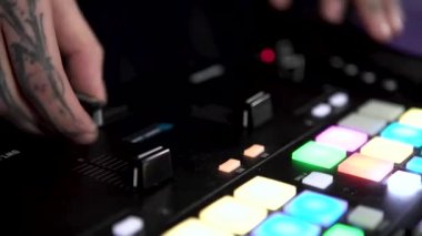 Dövmeli DJ elleri düğmelere ve sürgülere basar, elektronik müzik çalar. - Sanat. Parti, gece kulübü ve tekno müzik kavramı.