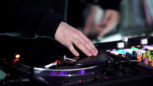 Primer plano de DJ en la discoteca está trabajando detrás del control remoto. Art. Tecno música en el club nocturno, equipo de música profesional. —  Fotos de Stock