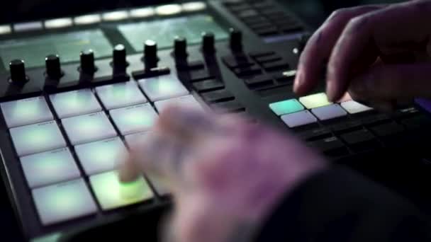 Close up of dj working with the professional drum machine at the night club. Art. Young man tapping fast on the buttons of a beat making machine. — Stock Video