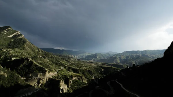 Skalnaté zelené hory na zamračeném pozadí oblohy, letecký výhled. Akce. Horské pohoří pokryté zelení, Nový Zéland. — Stock fotografie