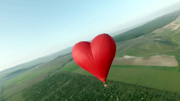 Vuelo en globo aerostático en forma de corazón. Le dispararon. Vuelo romántico en globo en forma de corazón para pareja. Recién casados pareja o pareja de amantes están volando en globo aerostático — Vídeo de stock