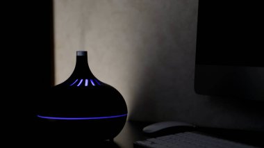 Aromaterapi yağı yayıcı ve koyu arkaplandan çıkan renkli LED ışığı. Kavram. Aromatik nemlendirici evdeki bir masada..