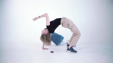 Anne ve kız beyaz bir arka planda izole halde eğleniyorlar. Şarjör. Modern ebeveynlik kavramı, kadın köprü yapıyor ve kızı ona akıllı telefon veriyor..