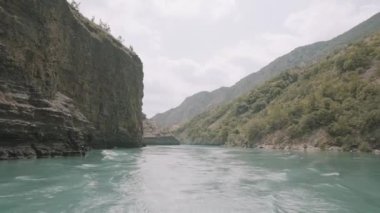Yeşil dağlar arasında akan turkuaz bir nehrin nefes kesici manzarası. Başla. Seyahat ve macera kavramı, bir vadide vahşi geniş bir nehri keşfetmek..