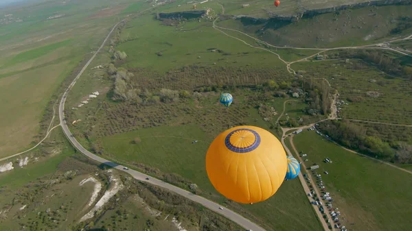 Le drone vole par des ballons. Fusillade. Vue de dessus de beaux ballons de près. Festival de ballon sur les champs verdoyants et le rock par une journée ensoleillée. Ballons colorés dans le ciel — Photo