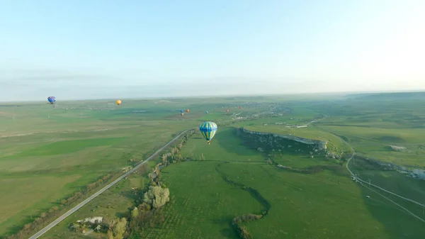 Vista superior del festival de globos. Le dispararon. Hermoso panorama con globos sobre fondo de campos verdes y horizonte. Paisaje con globos y horizonte en día soleado — Foto de Stock