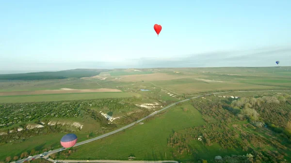 Globo en forma de corazón. Le dispararon. Vuelo romántico para pareja en globo en forma de corazón. Globo en forma de corazón vuela sobre los campos al amanecer. Globo para vuelo de amantes — Foto de Stock