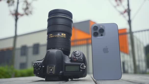 RUSSIA, MOSCOW - SEPTEMBER 27, 2021: Camera and phone comparison. Action. Professional camera with lens or new iPhone. Comparison of cameras of new iPhone 13 pro with professional camera — Stock Video