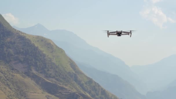 Вид з повітря на квадрокоптер, що летить над зеленими горами на фоні ранкового туману. Дія. Дрон знімає відео природного ландшафту . — стокове відео