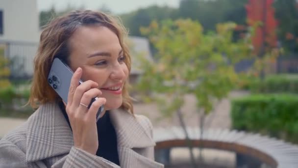 RUSIA, MOSCÚ - 27 de septiembre de 2021: Una hermosa mujer está hablando por teléfono. Acción. Mujer con estilo está hablando por teléfono nuevo. Mujer de negocios habla en el nuevo iPhone 13 — Vídeo de stock