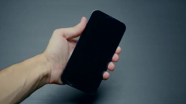 RUSSIA, MOSCA - 27 SETTEMBRE 2021: Logo quando si accende il telefono. Azione. L'uomo ha acceso il nuovo telefono e lo schermo si è illuminato. Abilitare il nuovo iPhone 13 pro con logo Apple — Video Stock