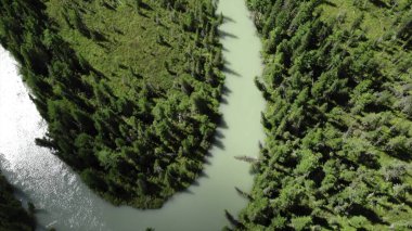 Turkuaz nehri, yemyeşil bitki örtüsü ve kayalık araziyle çevrili pitoresk bir vadiden geçiyor. Medya