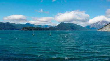 Uçsuz bucaksız bir körfezin güzel turkuaz sularında yüzen iki yelkenli. Dağlık bir kıyı şeridi var. Medya