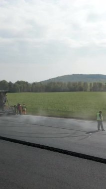 Yol silindirleri ve kaldırımlar yeni bir asfalt yolda çalışıyor