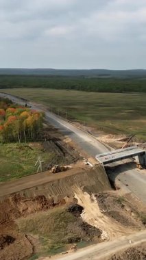 İnşaat işçileri kırsal alanda bir otoyol üzerine köprü inşa ediyorlar.
