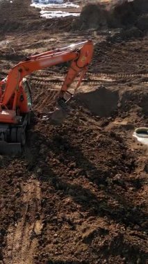 Ağır kazıcı verimli bir şekilde bir inşaat alanında siper kazıyor, toprağı hareket ettiriyor ve açık gökyüzünün altında gelişim için zemin hazırlıyor.