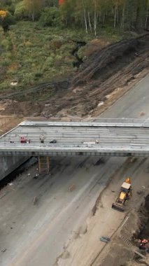 İnşaat işçileri yeni bir otoyol üst geçidi için ön döküm beton kirişler kuruyor