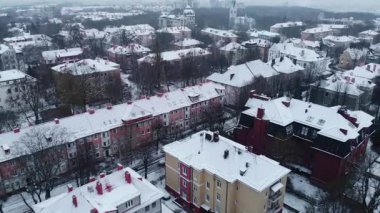 İnsansız hava aracı şehir binaları ve caddelerin üzerinde uçuyor. Taze kış karlarıyla kaplı. Medya
