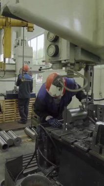 Metal işleme fabrikasında ağır makineler çalıştıran sanayi işçileri