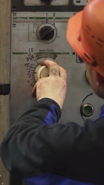 Ağır makinelerin kontrollerini ayarlayan sanayi işçisi