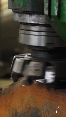 Metal fabrika makinesi bir metal işçiliği kesiyor, kıvılcımlar çıkarıyor.