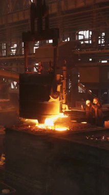 Çelik fabrikasında işçilerin kullandığı bir kalıba erimiş metal dökme süreci.