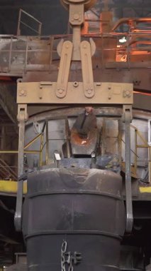 Çelik fabrikasındaki endüstriyel vinç tarafından kaldırılan erimiş metal.