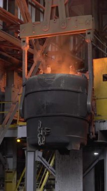 Erimiş metal, çelik fabrikasındaki büyük bir konteynırdan başka bir konteynere dökülüyor.