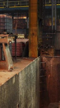 Dökümhanede erimiş metali kaldıran endüstriyel vinci kontrol eden işçiler