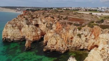 Turkuaz havuzlu dramatik kıyı kemerleri, oyulmuş mağaraların ve kemerlerin hava görüntüleri.