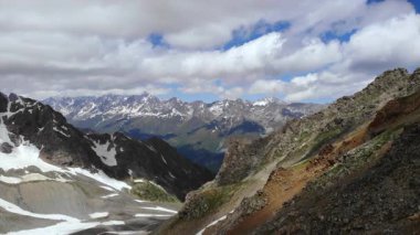 Karlı dağ manzarası, engebeli kayalık tepe, dramatikliğin altındaki uzak kar tepeleri. Medya