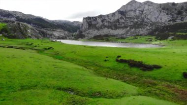 İnsansız hava aracı çarpıcı yeşil bir çayırın üzerinden vadideki el değmemiş bir dağ gölüne doğru uçuyor. Medya