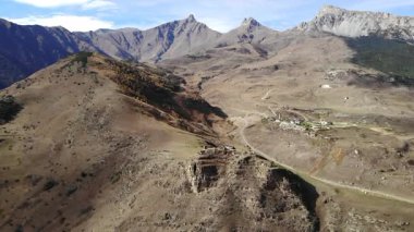 Uzak antik bir köyün manzaralı manzarası ve kafkas dağlarında yuva yapmış harabeler. Medya