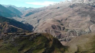 İnsansız hava aracı görüntüleri dağın tepesindeki eski harabelerin üzerinde uçuyor, derin bir vadi ve sırtı ortaya çıkarıyor. Medya